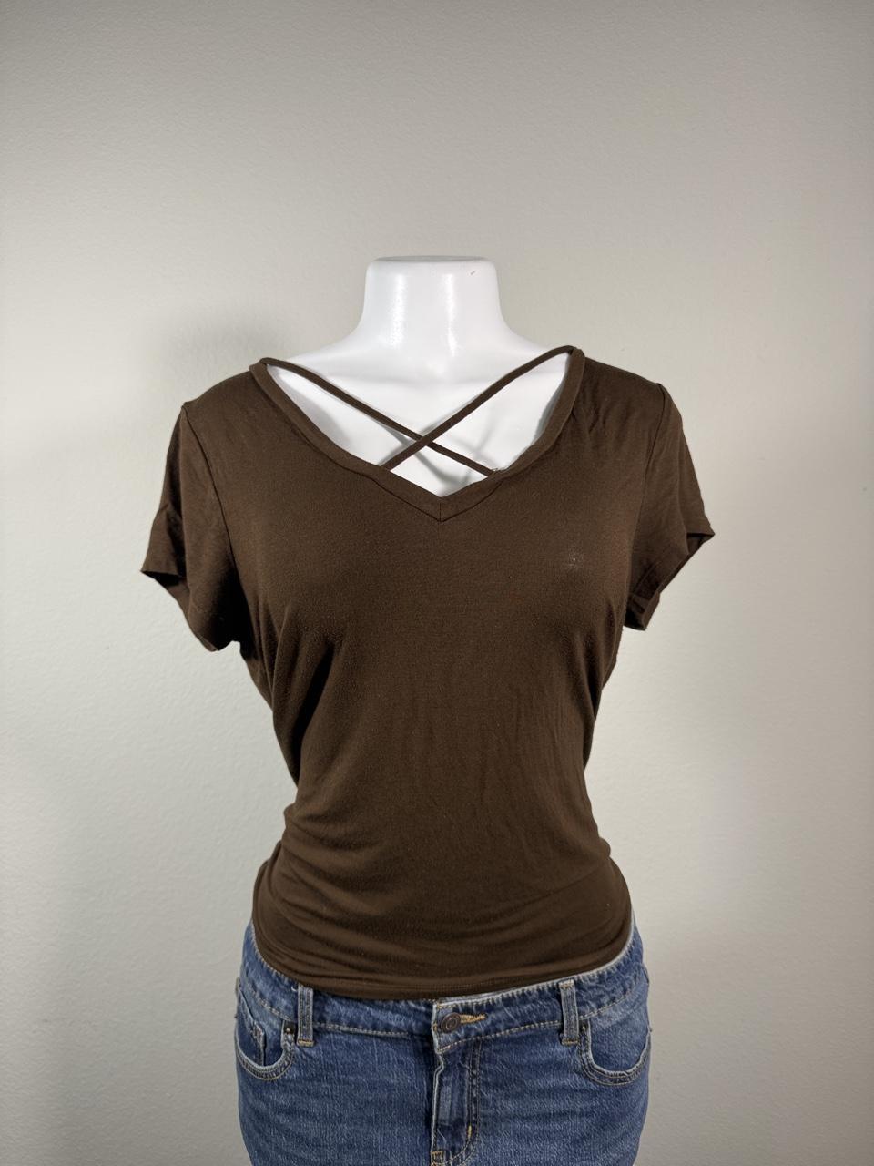 Y2K brown criss cross V-neck tee featuring a flattering fitted silhouette and soft stretchy fabric. A versatile everyday essential that's perfect for pairing with low-rise jeans, cargos, or layering for an effortless early 2000s look.