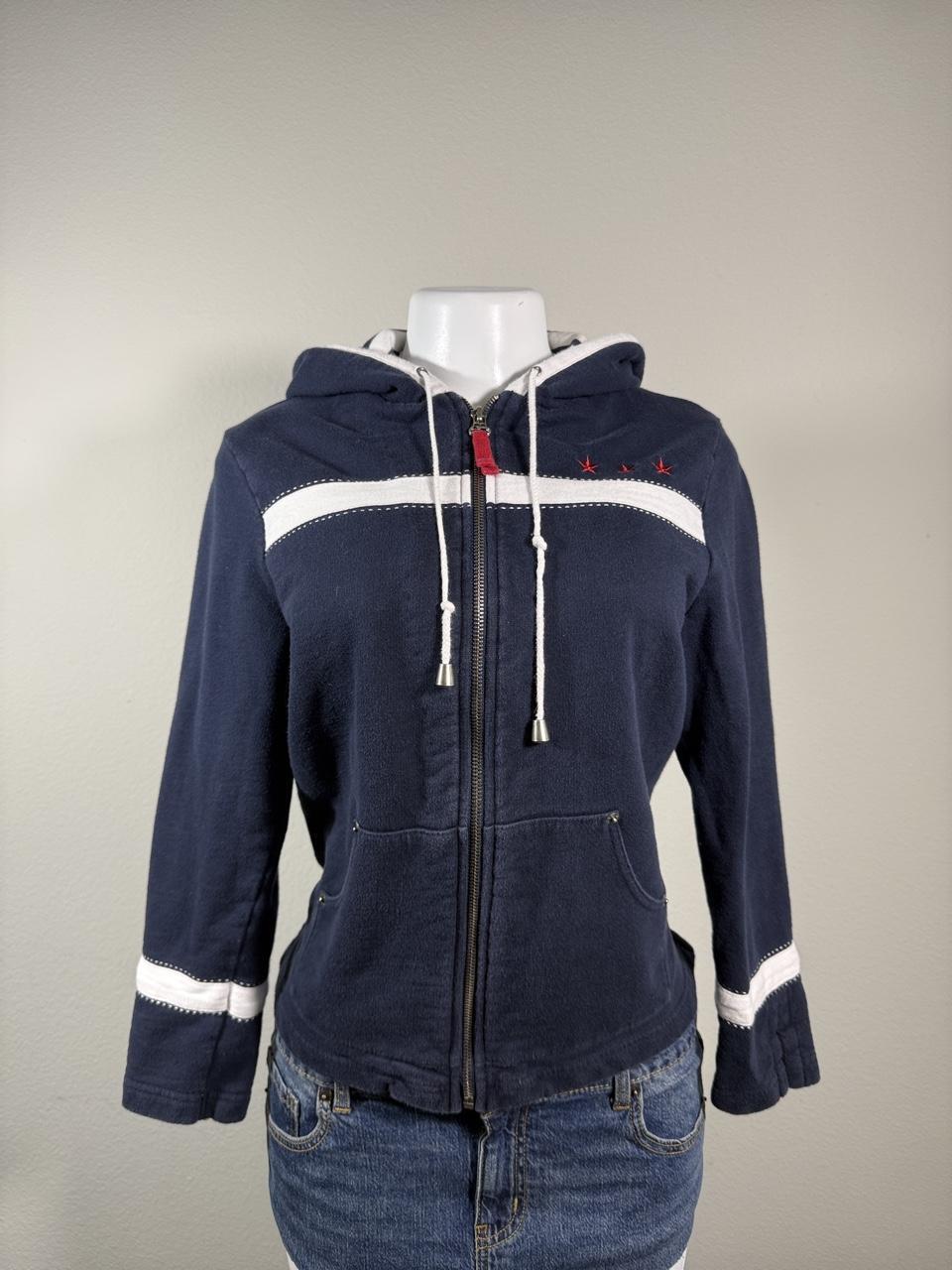 Y2K Studio Norton navy zip-up hoodie featuring sporty white stripe details, red embroidered stars, and a cozy hood with adjustable drawstrings. A classic early 2000s layering piece that's perfect with jeans, cargos, or athleisure looks.