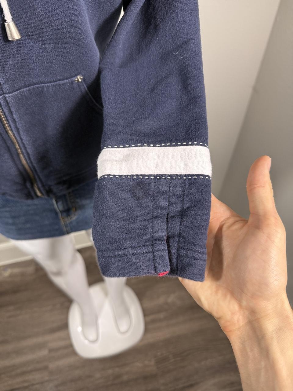 Y2K Studio Norton navy zip-up hoodie featuring sporty white stripe details, red embroidered stars, and a cozy hood with adjustable drawstrings. A classic early 2000s layering piece that's perfect with jeans, cargos, or athleisure looks.