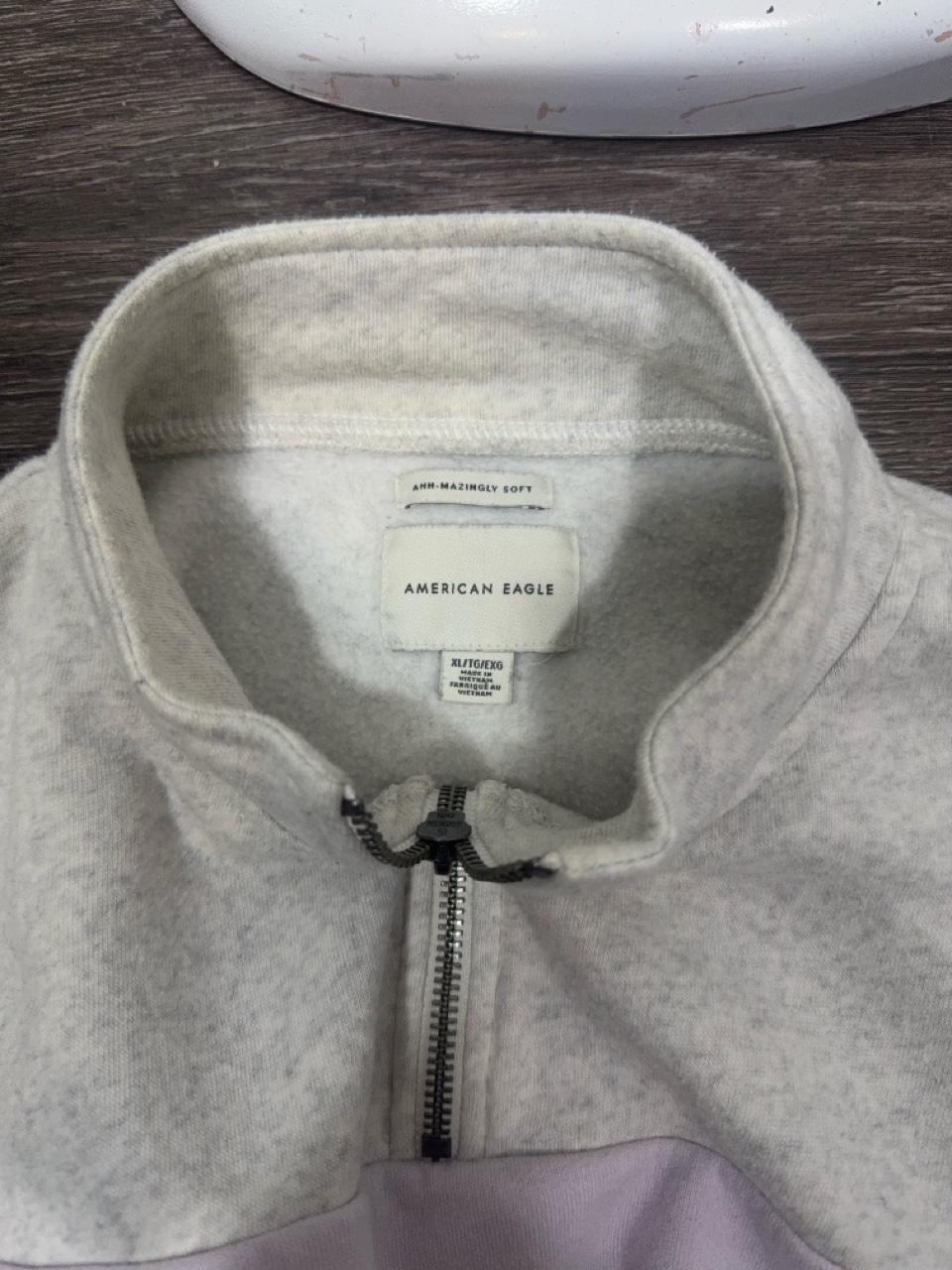 Y2K American Eagle colorblock quarter zip sweatshirt featuring soft fleece fabric in heather gray, lavender, and periwinkle blue. Finished with a mock neck, adjustable drawstring hem, and cropped silhouette for the perfect cozy Y2K look.